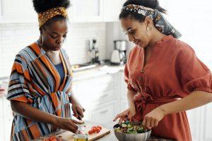 two women making a salad - healthy food for hair