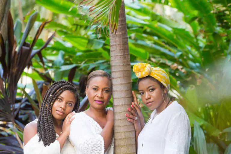 A close-up photo of three African American women in a tropical forest - care for and style hair in any weather