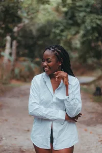 Afrian American woman with long locs and a white shirt.